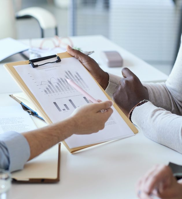 Close up of business team pointing at data chart Close up of business team pointing at data chart