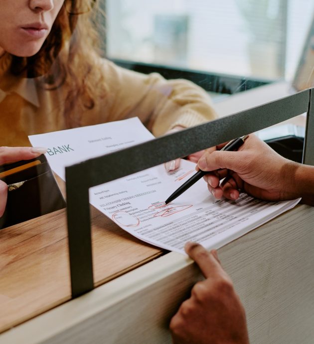 Person Filling Out Bank Documents in Office Person Filling Out Bank Documents in Office